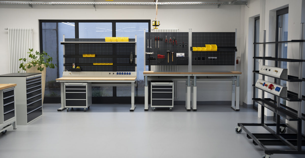 Moderner, ergonomischer Industriearbeitsplatz mit höhenverstellbarem Werktisch, Computerstation und Werkzeuglagerung