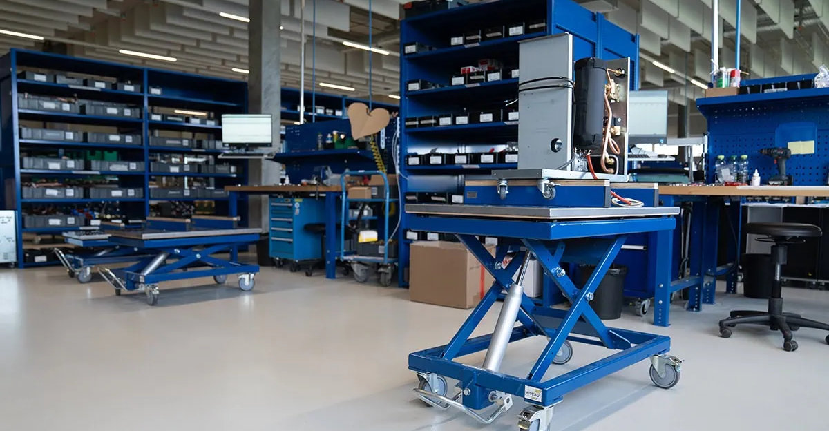 Mitarbeiter bedient einen ergonomischen Scherenhubtisch zur Materialbereitstellung