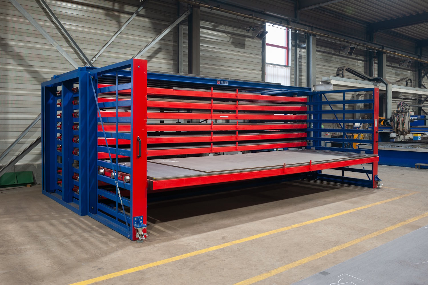 Schubfachregal für Bleche von Bartels mit geöffnetem Schwenkvorbau und Vollauszug in einer Werkshalle